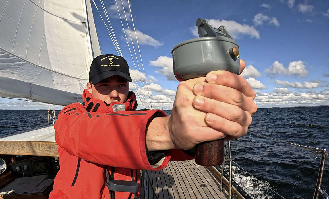 Vagtchefen tager en pejling med håndpejlekompasset.